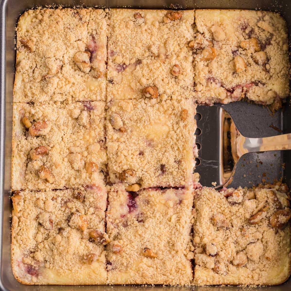 cranberry cream cheese bars in a pan with a spatula