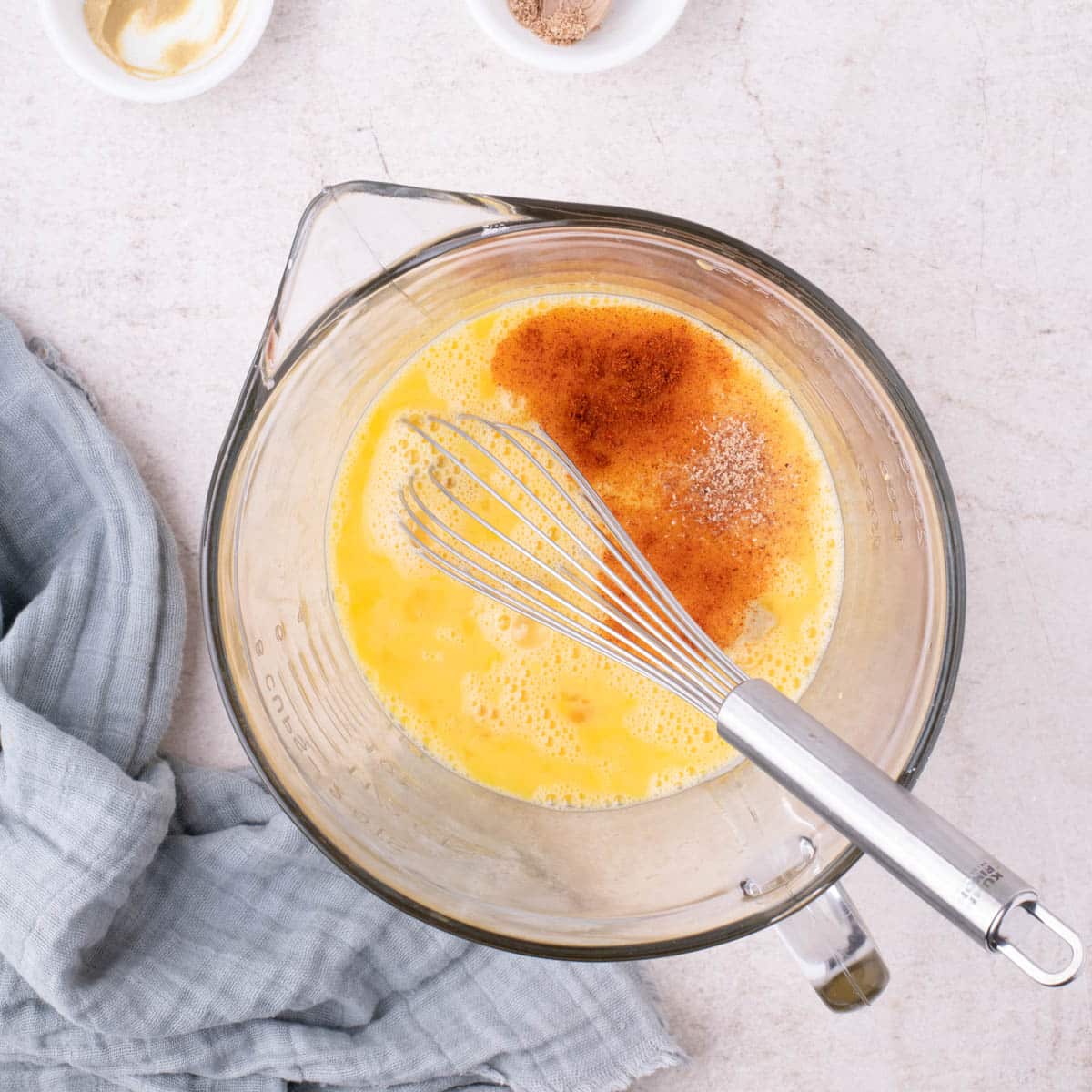 eggs whisked in a bowl with seasonings