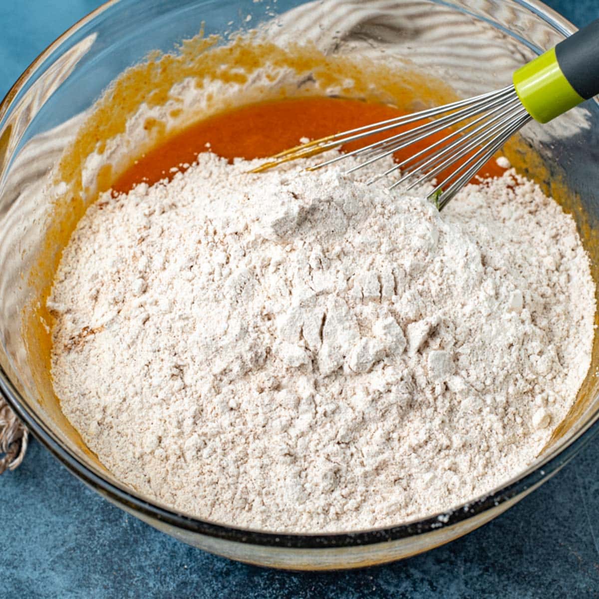 dry ingredients over pumpkin mixture in a bowl