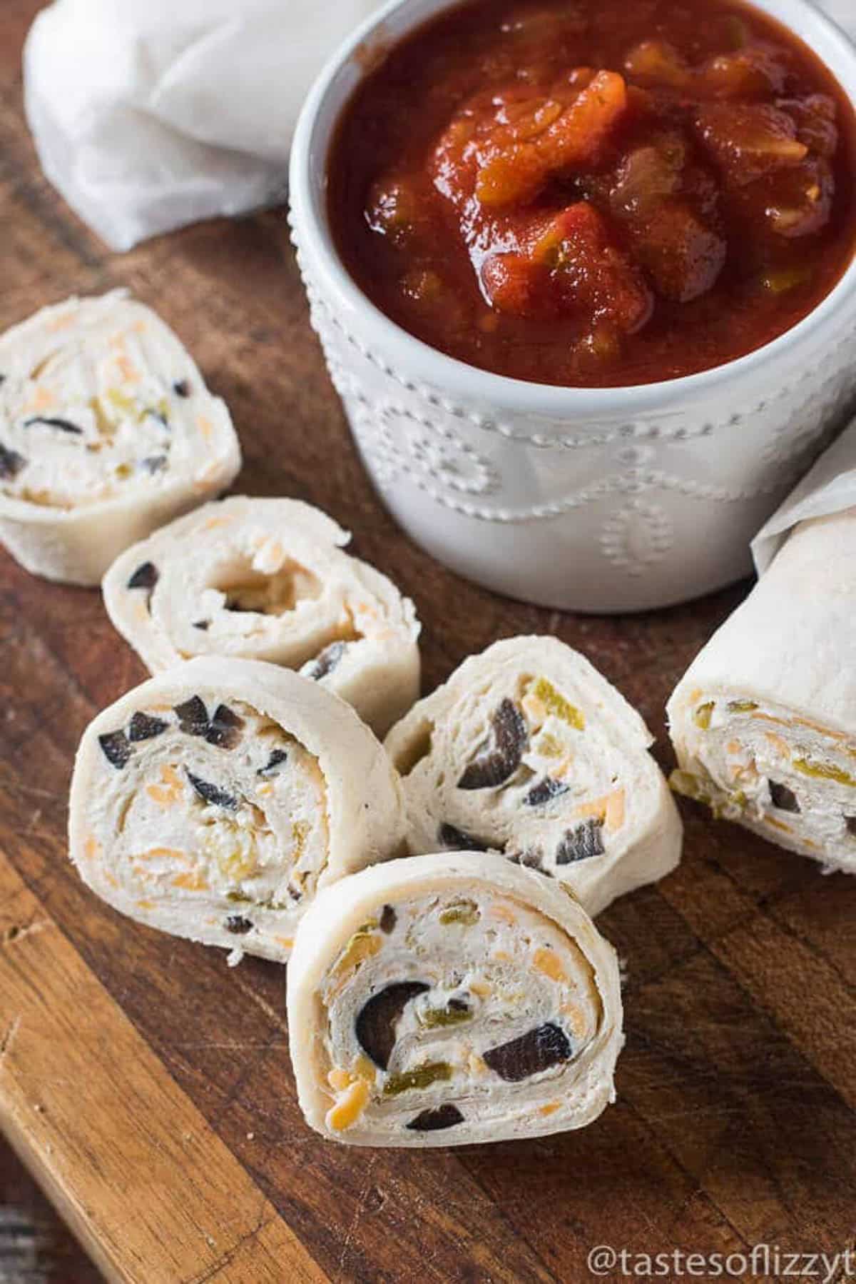 mexican pinwheels with salsa on a table