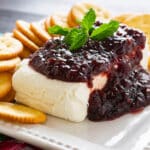 raspberry cream cheese dip on a plate with crackers