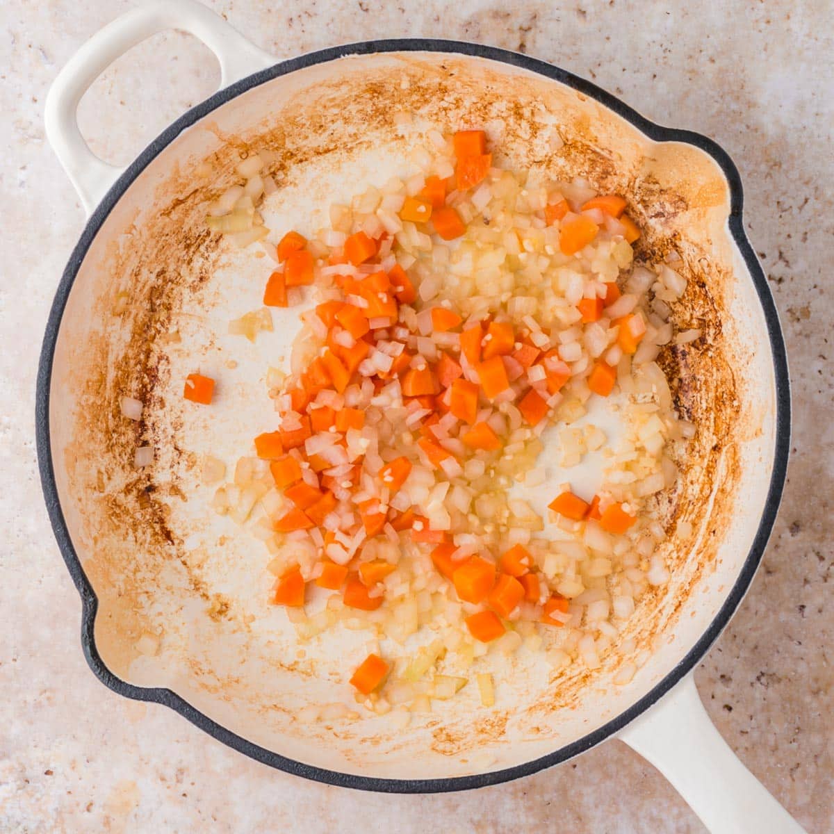 onions, garlic and carrots in a skillet