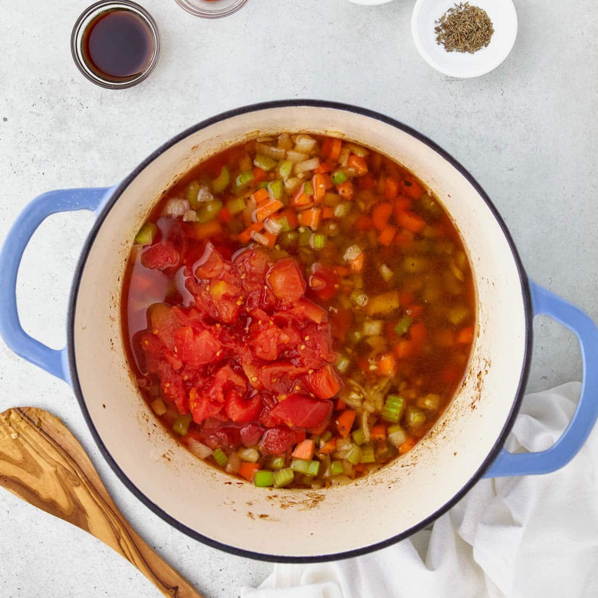 tomatoes, broth and veggies in a dutch oven