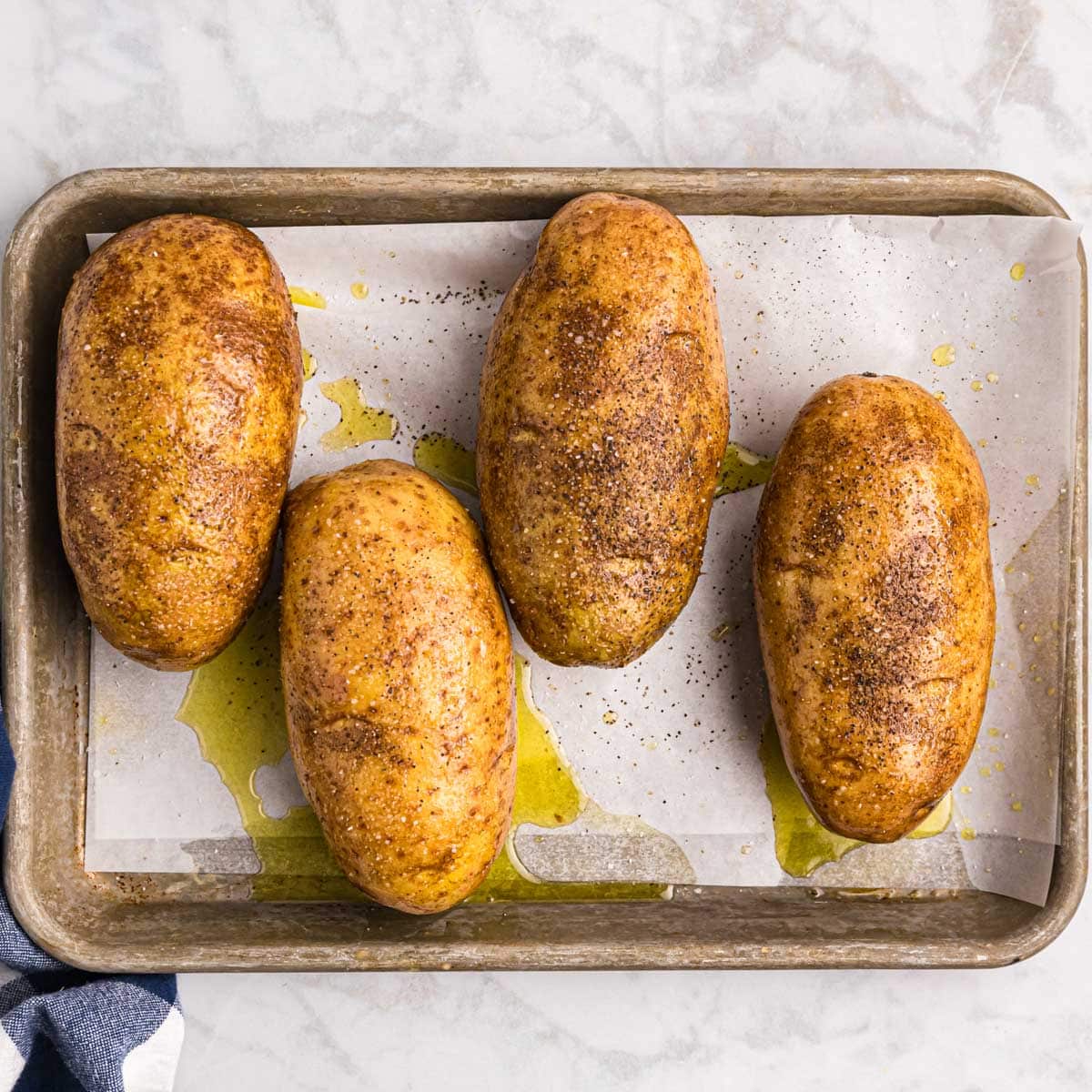 uncooked potatoes on a baking sheet