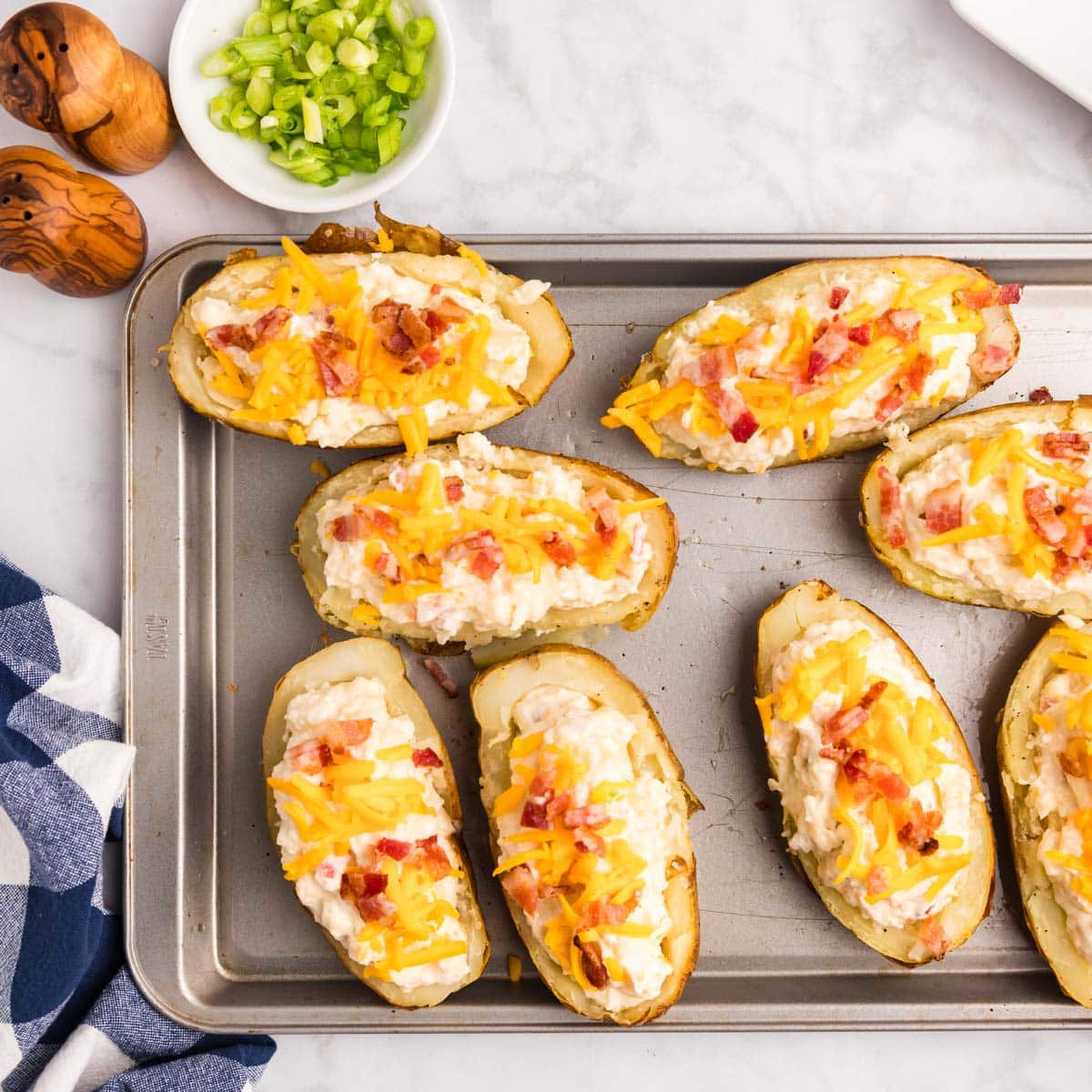 unbaked loaded potato halves on a baking sheet