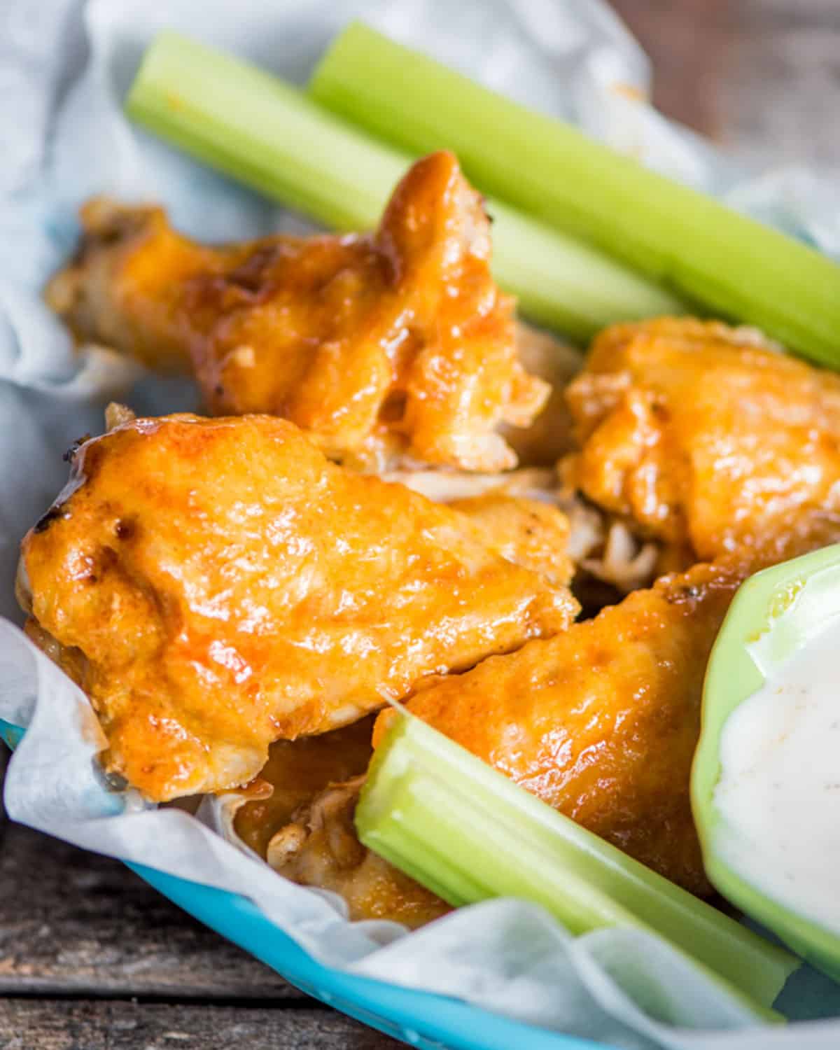 a basket of buffalo wings with celery