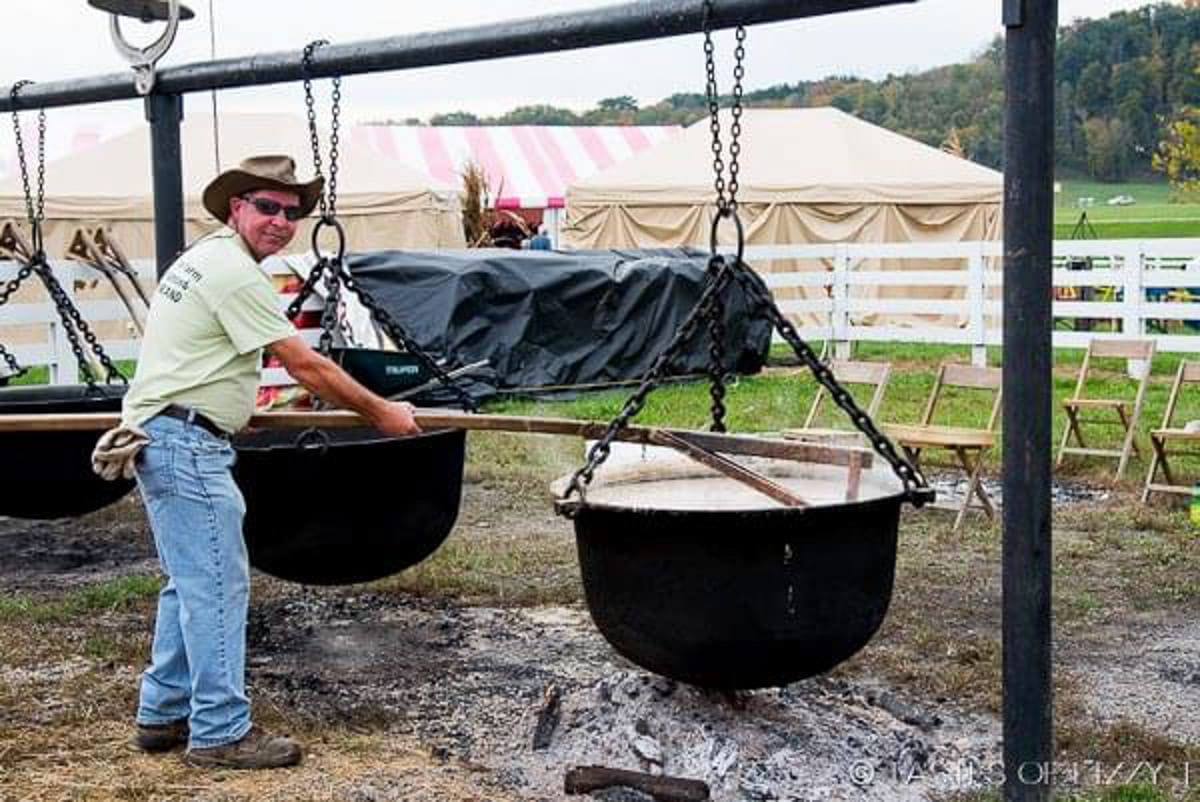 man stirring syrup in a large kettle