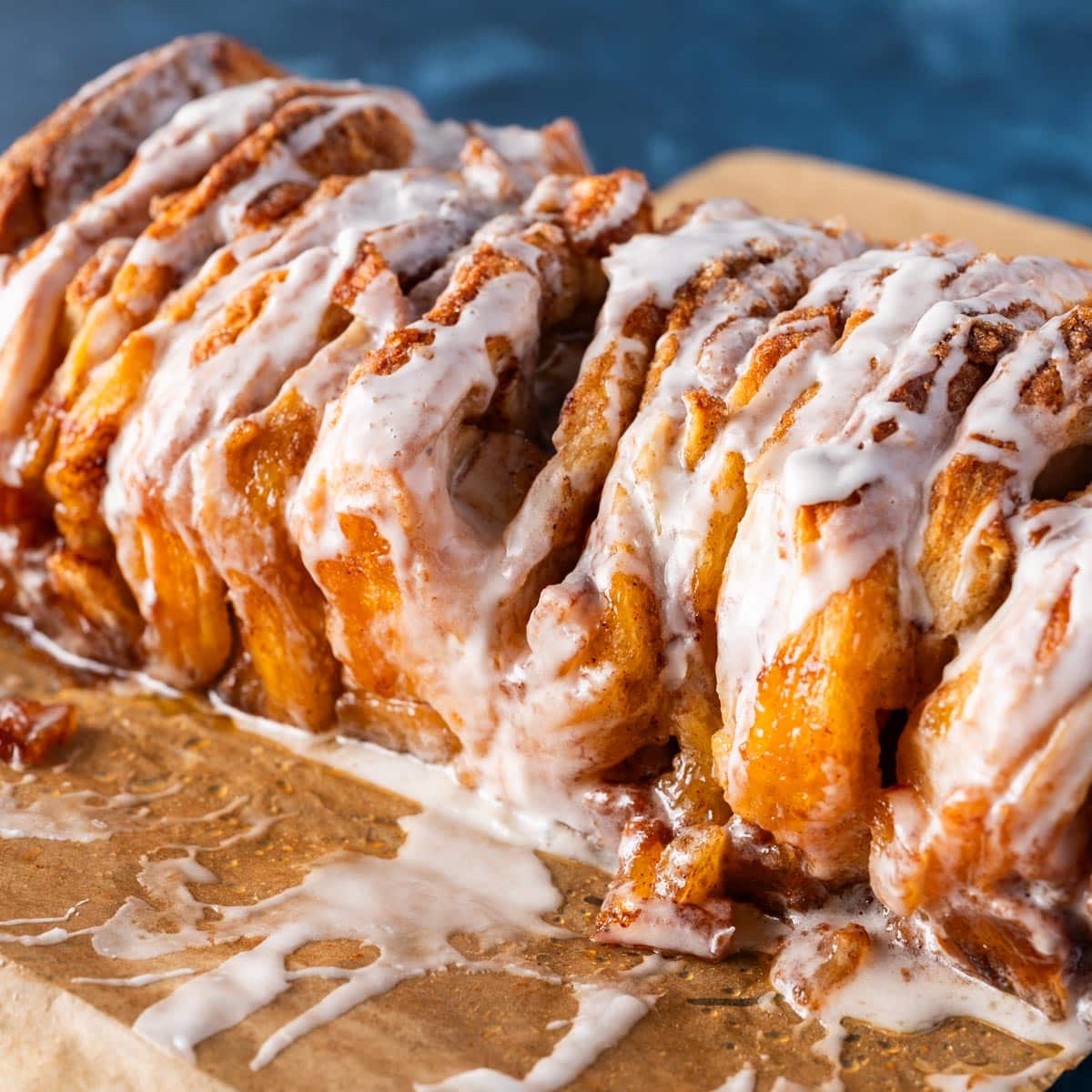 a loaf of glazed pull apart bread on parchment paper