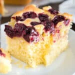 a piece of cherry cake on a plate with a fork