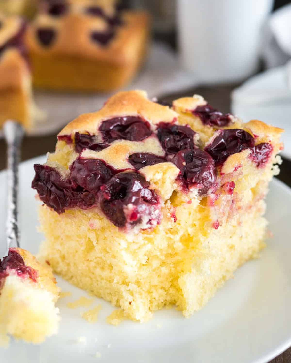 a piece of cherry cake on a plate with a fork