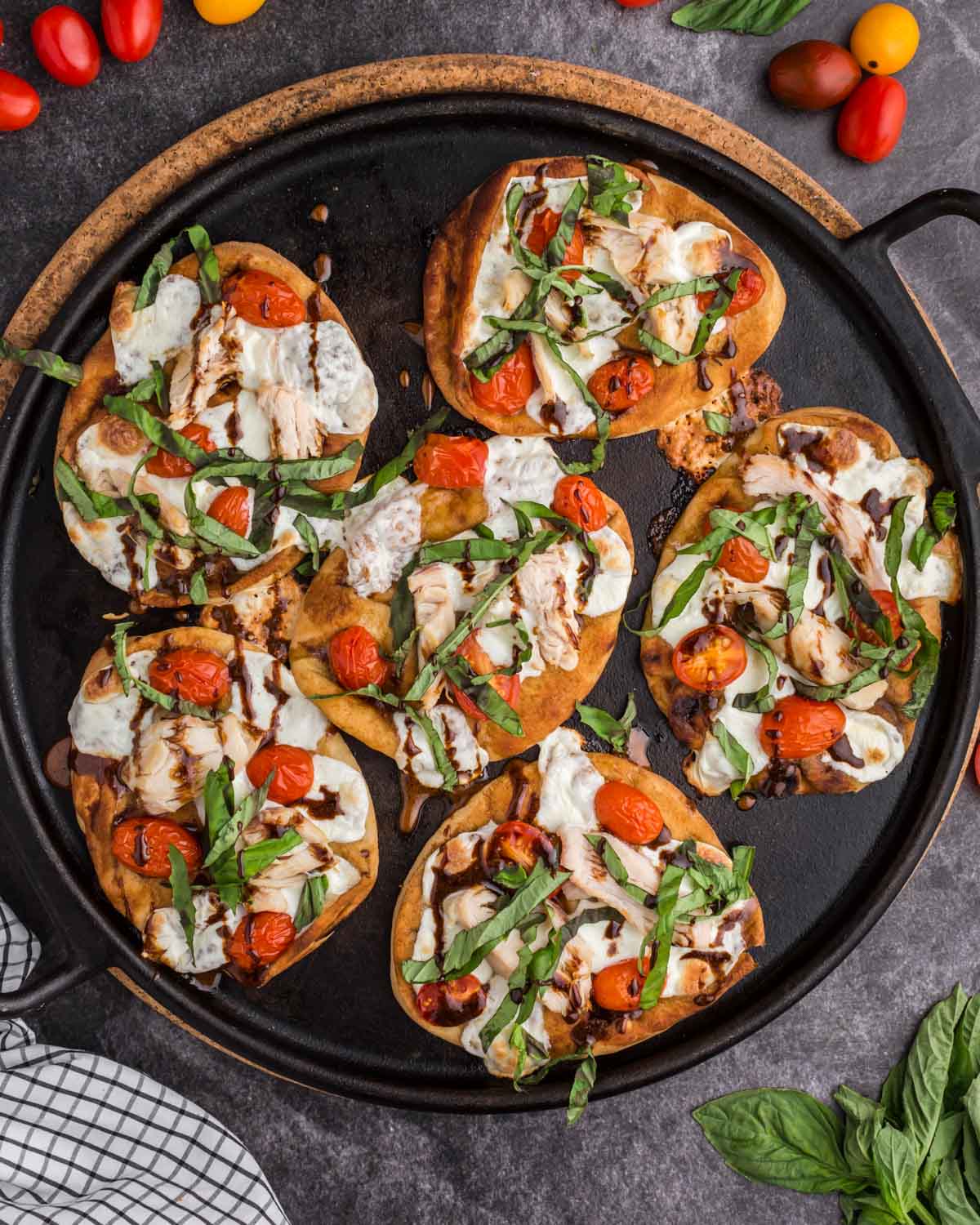 overhead view of chicken caprese pizzas on a skillet