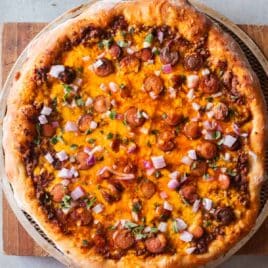 overhead view of chili pizza with hot dogs