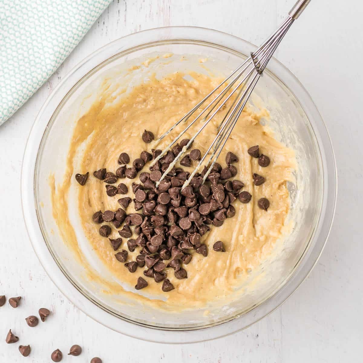 chocolate chips over donut batter in a bowl