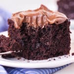 a piece of chocolate cake sitting on a plate with a forkful out