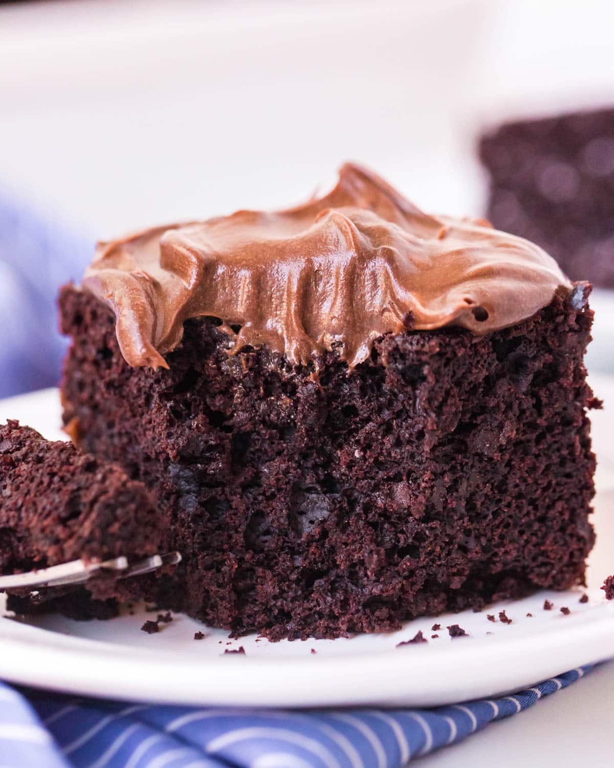 a piece of cake sitting on a plate with a forkful out