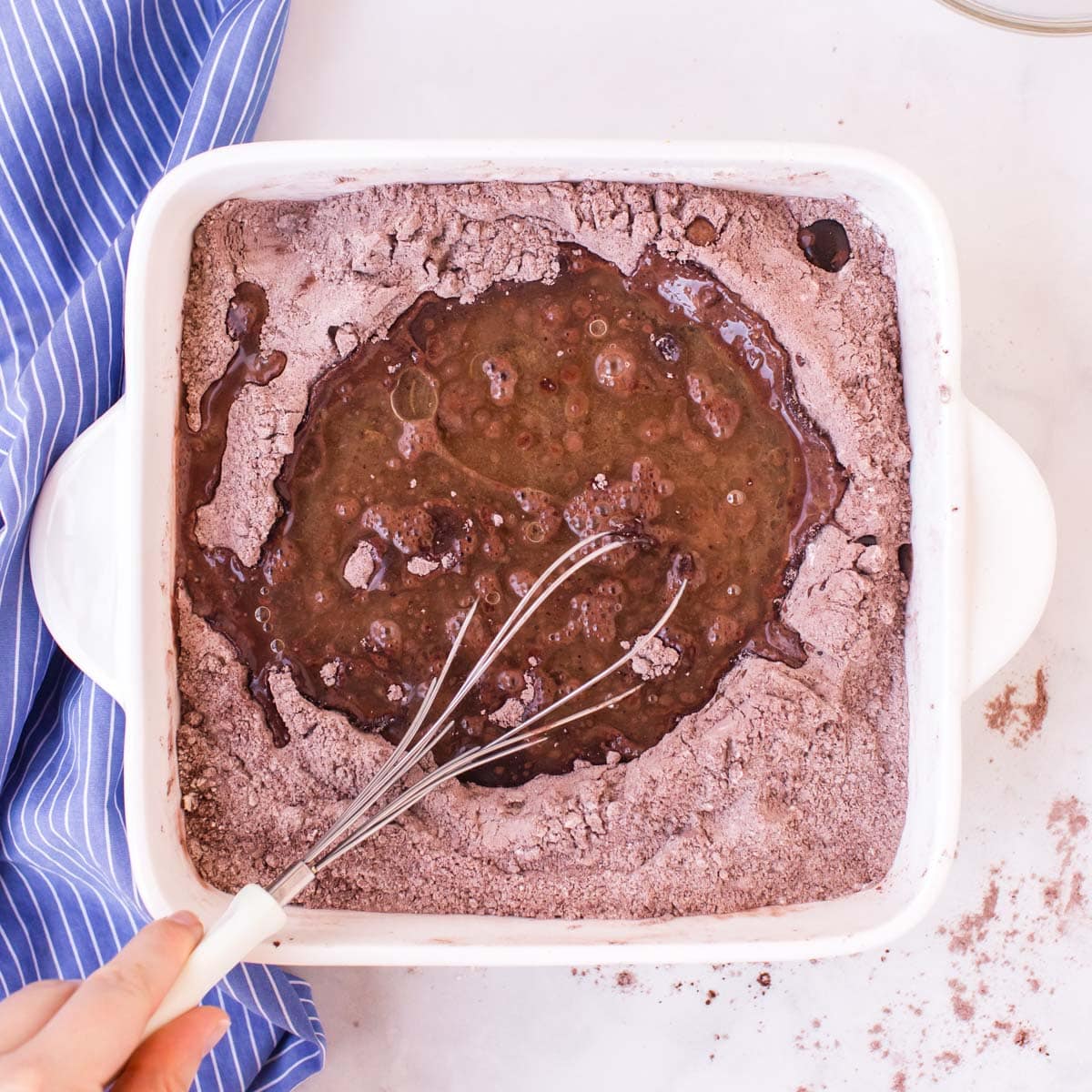 a whisk whisking cake batter in a pan