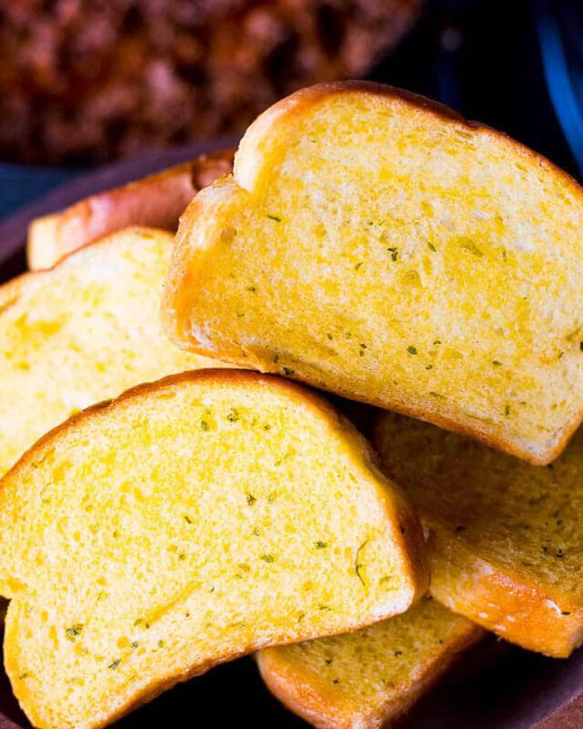 toasted garlic bread piled on a plate