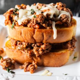 two pieces of garlic bread with spaghetti meat sauce