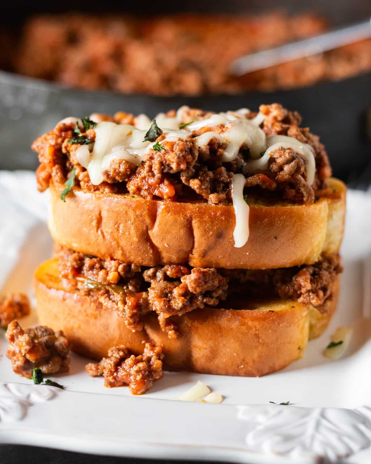 an italian sloppy joe sandwich with garlic bread on a plate