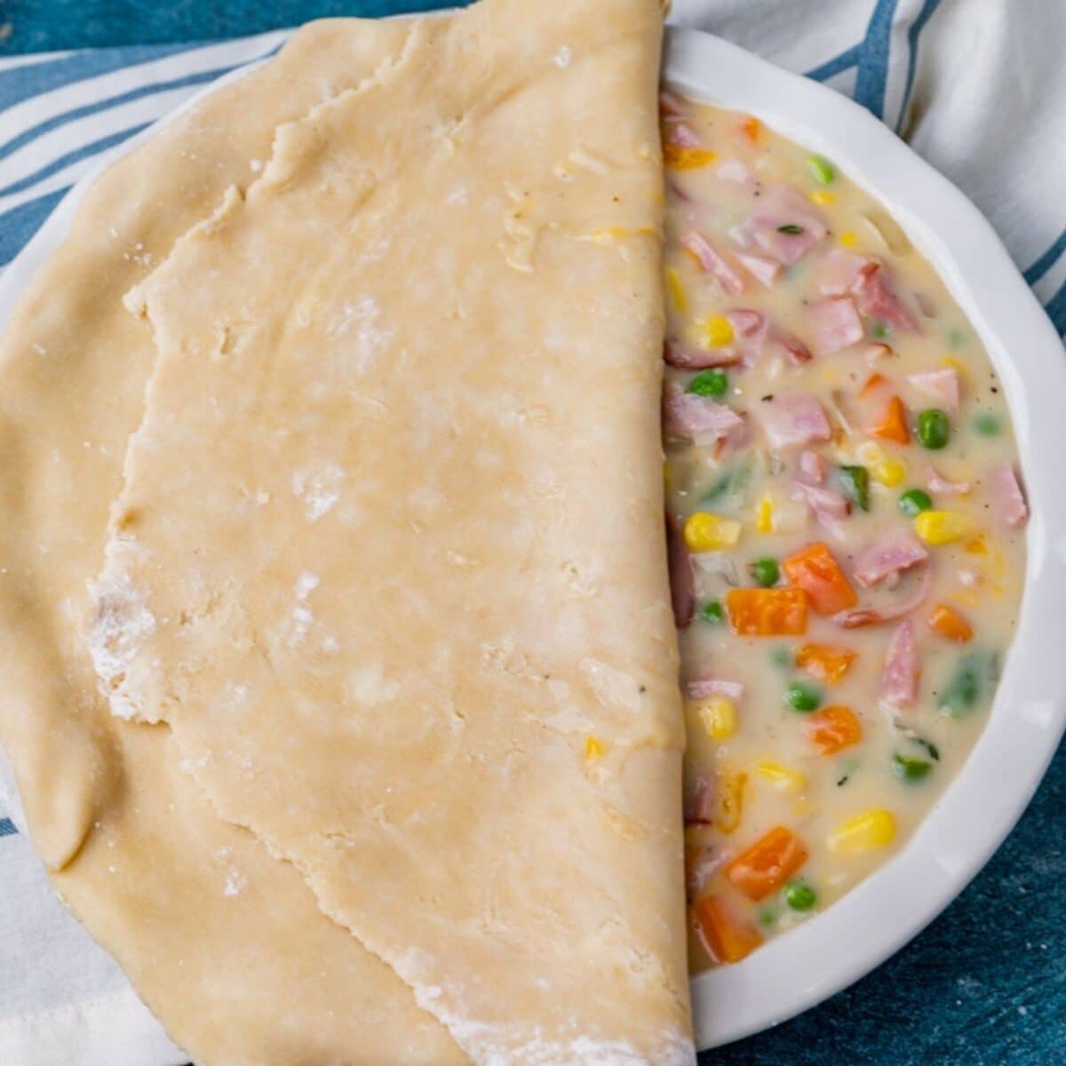 pie crust over ham pot pie filling in a pie plate