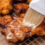 brushing honey butter over fried chicken