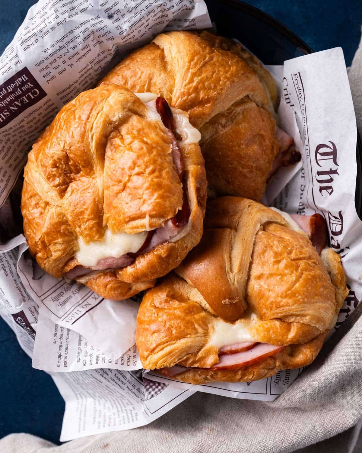 a basket of 3 hot ham and cheese croissants