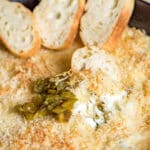 slices of bread in warm jalapeno popper dip