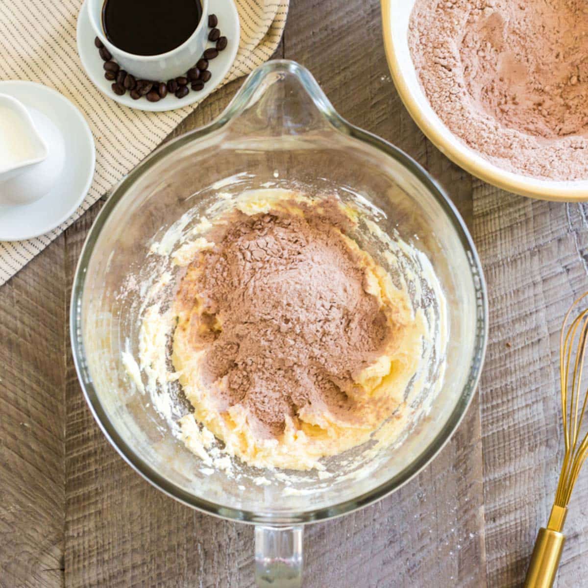 cocoa powder over creamed butter in a bowl