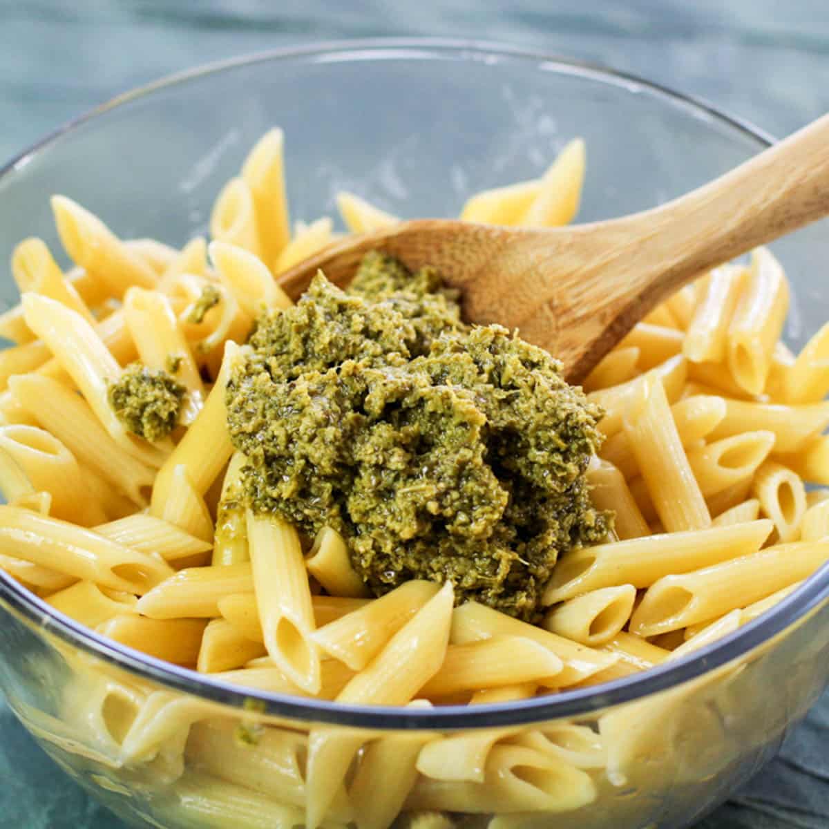 pesto over cooked pasta in a bowl