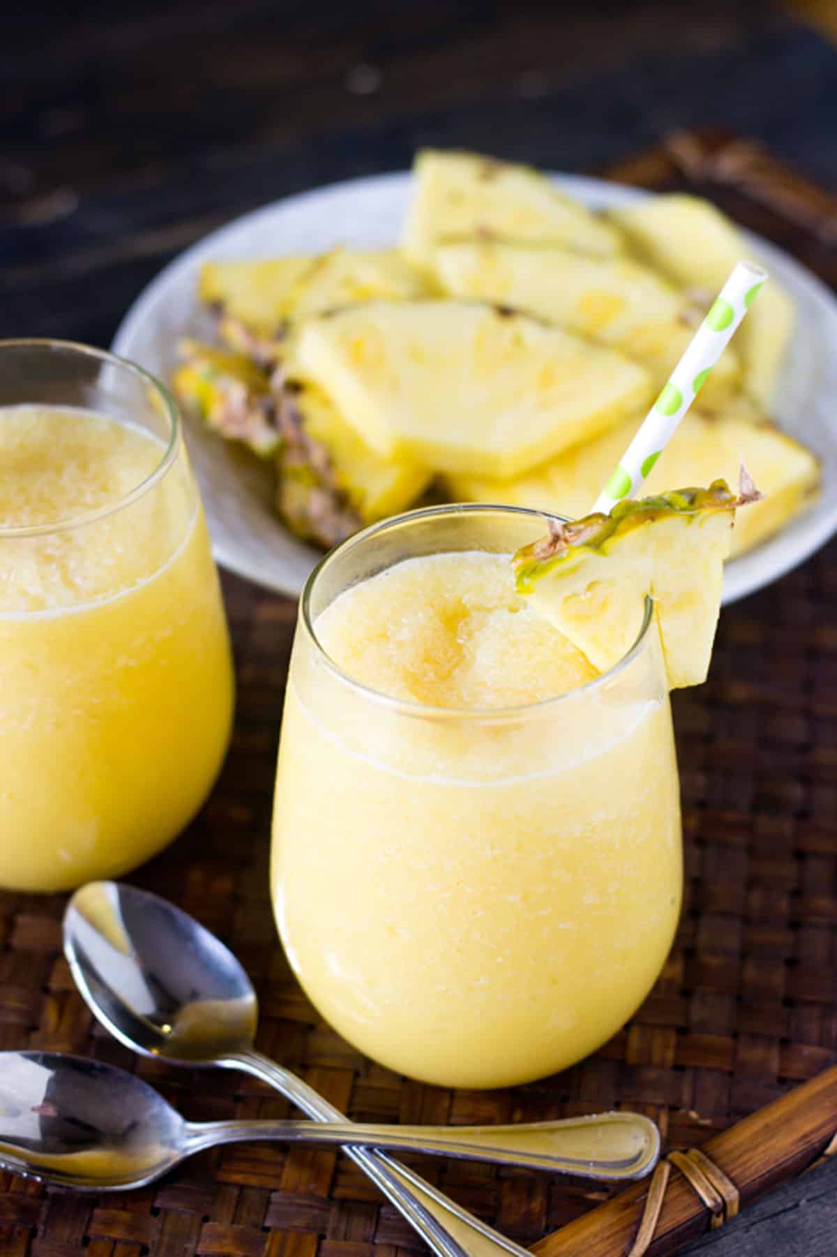 pineapple cream smoothie with a slice of pineapple and a straw