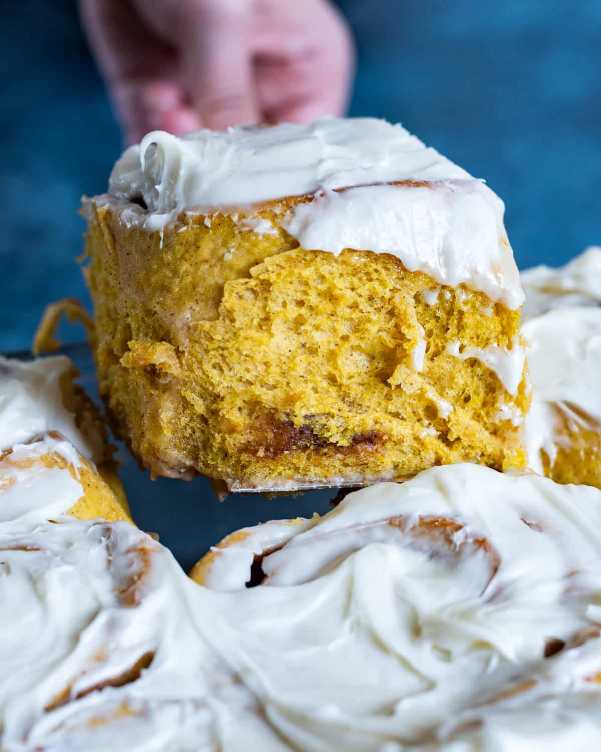 a spatula pulling out a pumpkin cinnamon roll