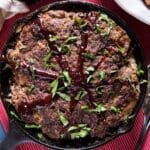 closeup of skillet meatloaf with barbecue sauce and parsley on top