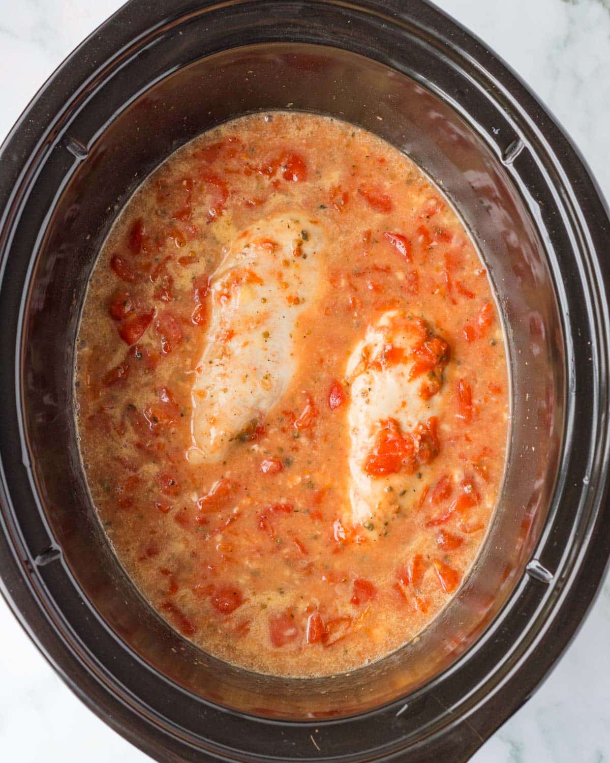 chicken cooked in a tomato sauce in a slow cooker