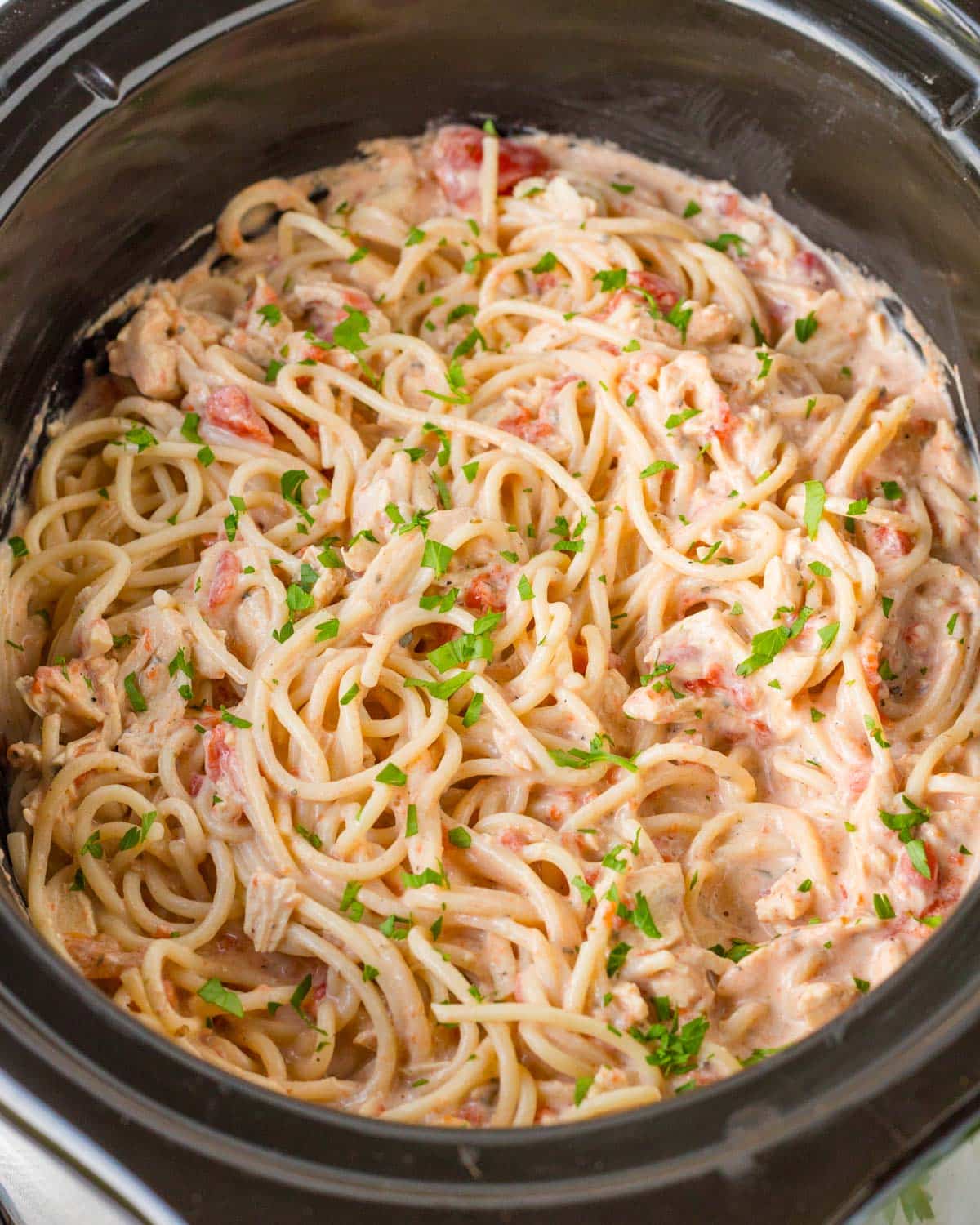 chicken spaghetti in a slow cooker with fresh parsley