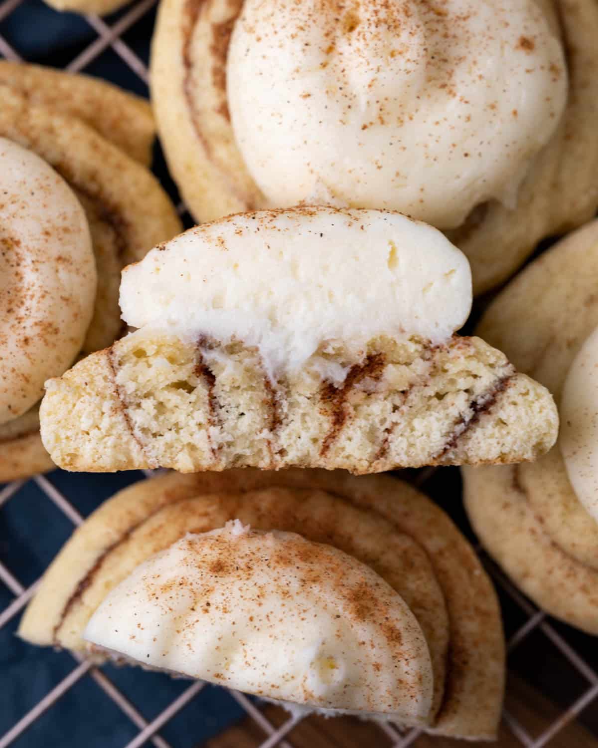 half of a cinnamon roll cookie on a pile of cookies