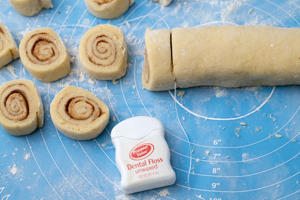 using floss to cut cinnamon roll cookie dough