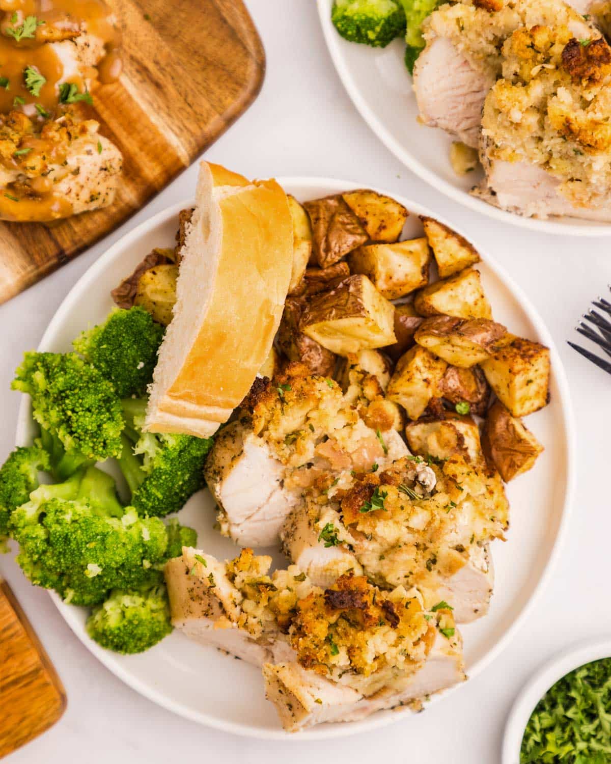 a plate of chicken breasts with stuffing, potatoes and broccoli