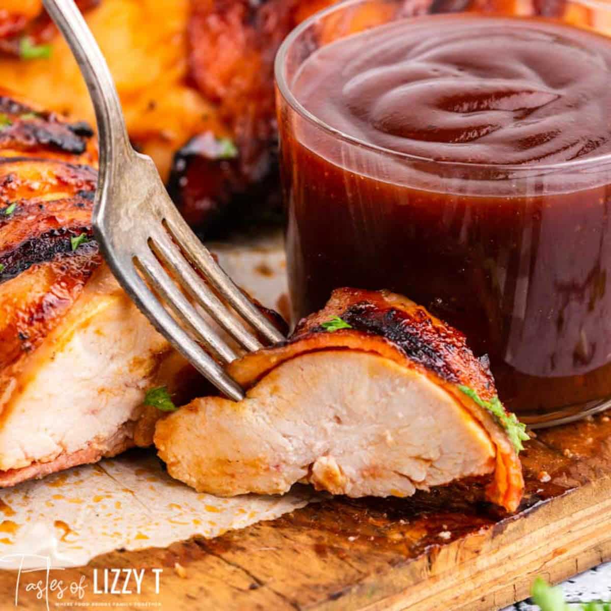 a fork cutting into a chicken breast on a table