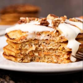 a stack of 4 carrot cake pancakes with vanilla glaze