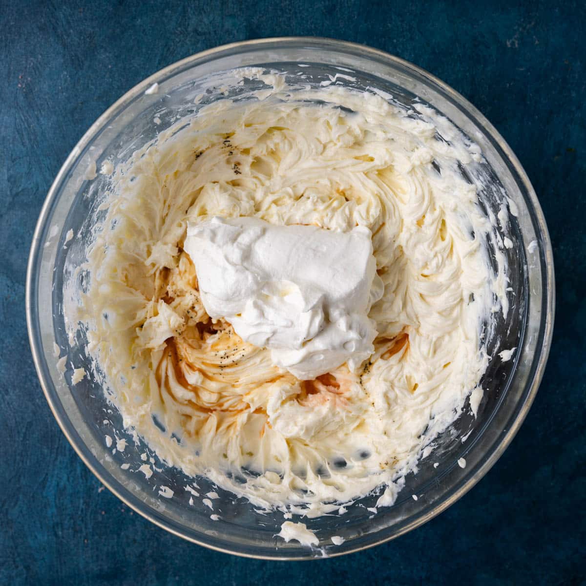 mixed cream cheese with sour cream and vanilla in a bowl