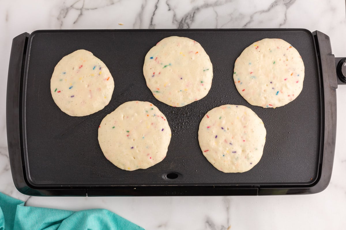 uncooked pancakes on a griddle