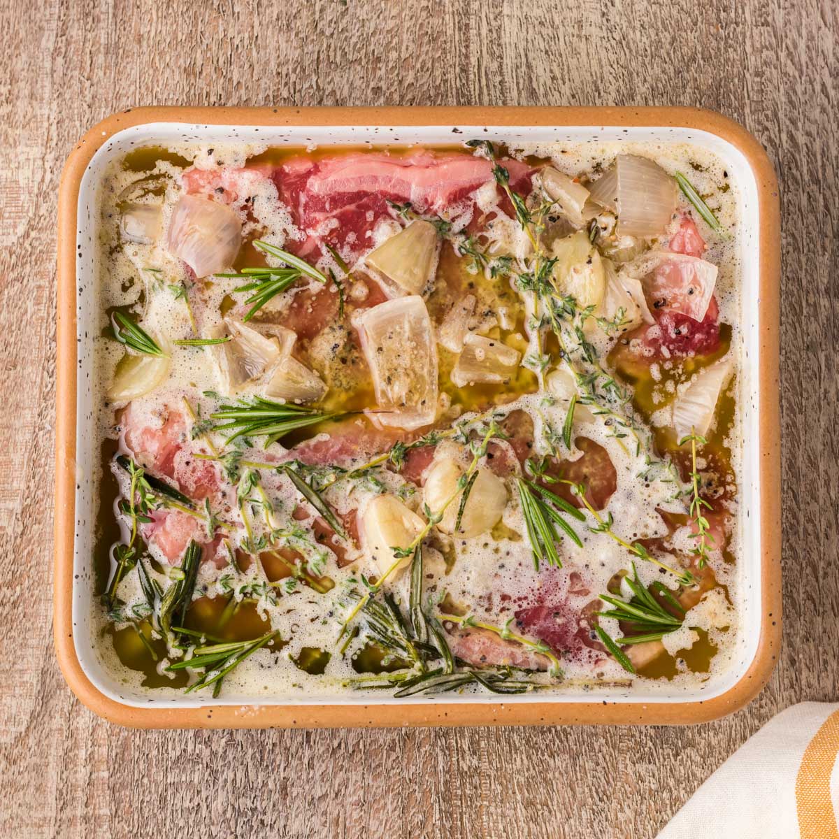 steak soaking in onions and butter and fresh herbs