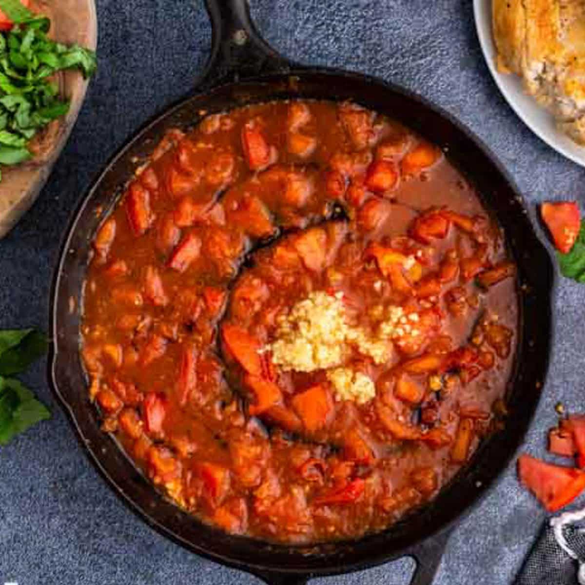 tomato sauce in a skillet with garlic on top