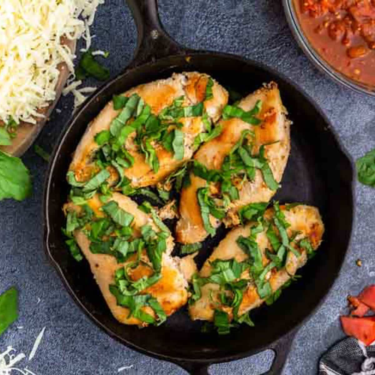 chicken with basil over the top in a skillet