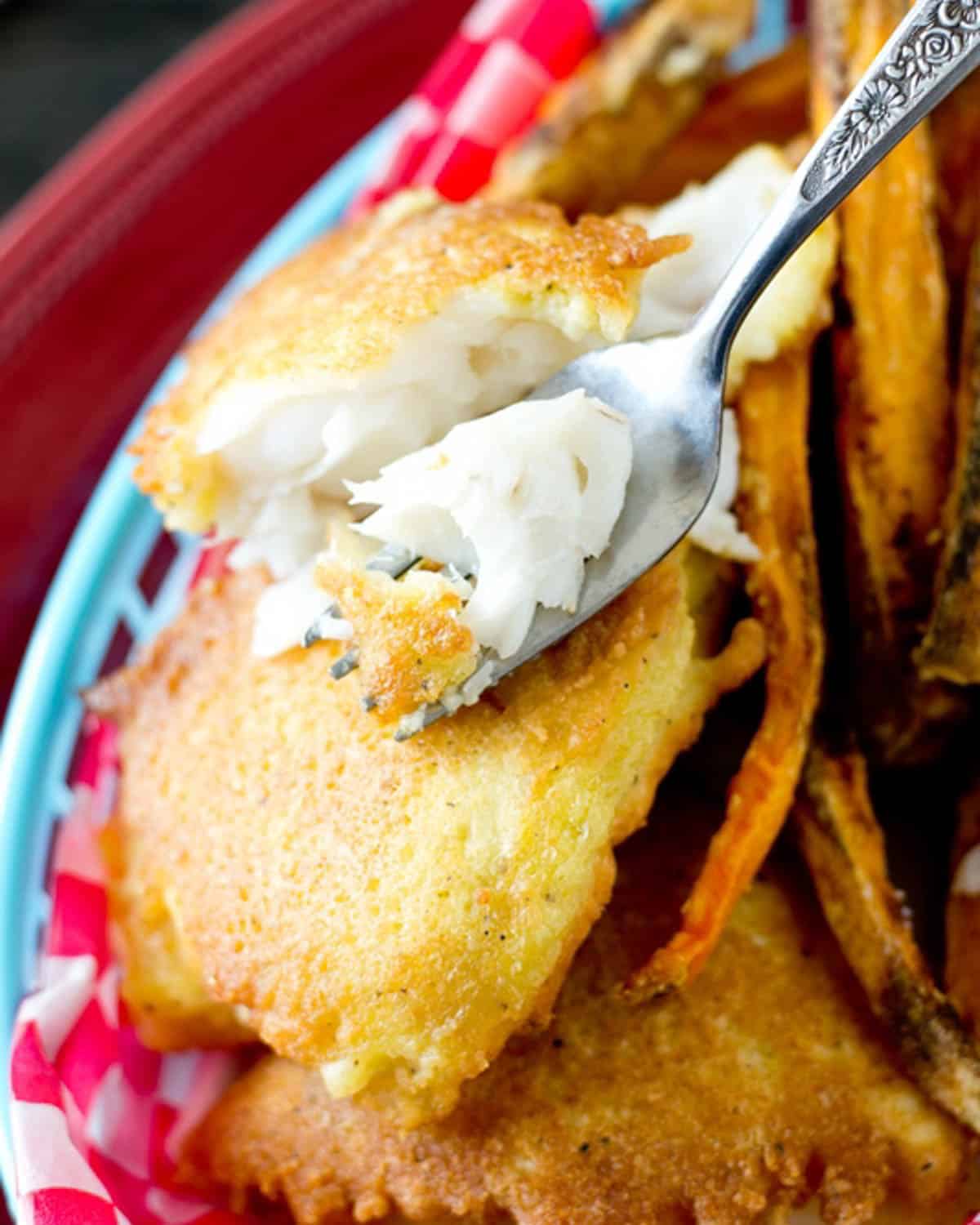 a fork with a bite of fried fish on it