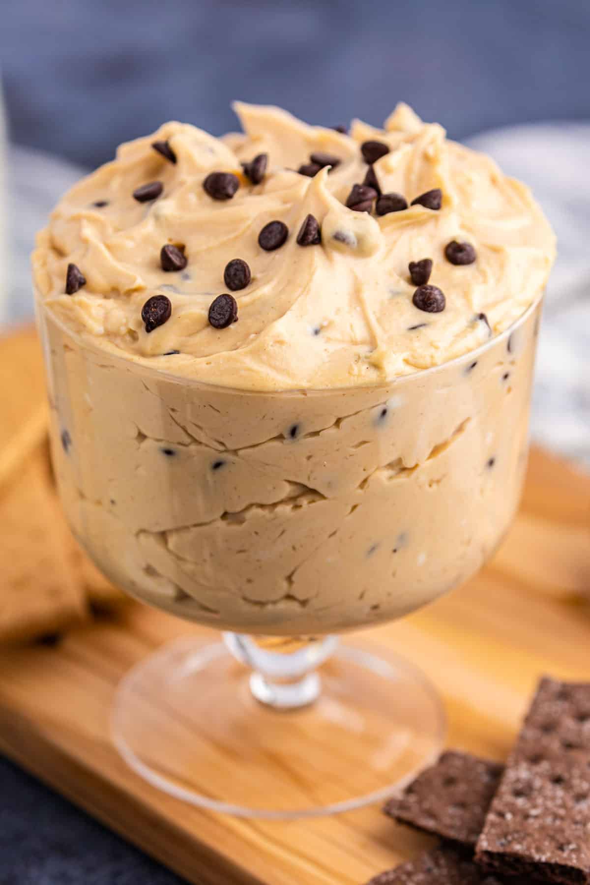 a bowl of peanut butter cheesecake dip with chocolate chips on top