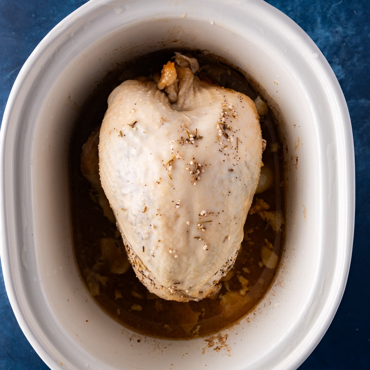 a cooked turkey breast in a slow cooker