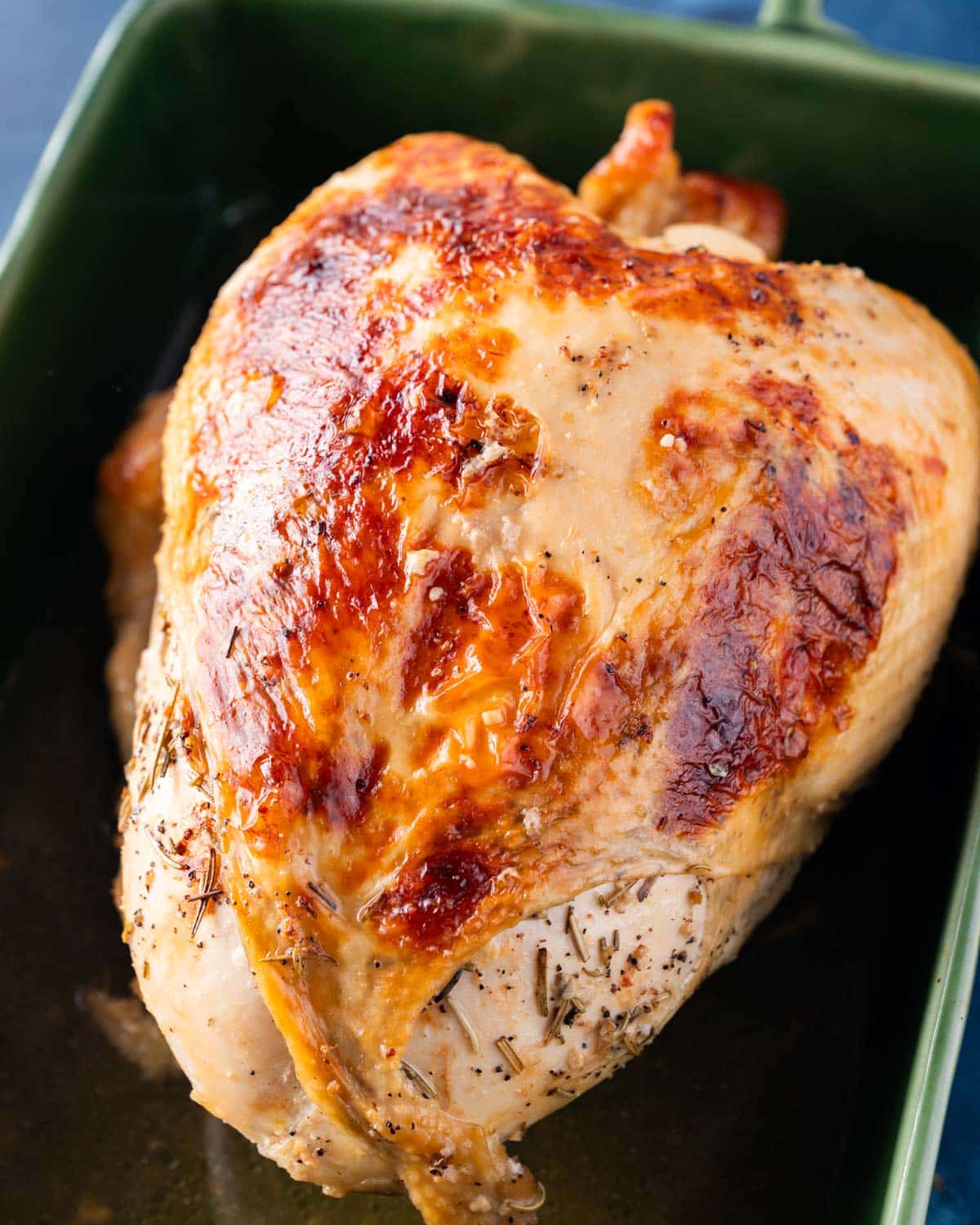 overhead view of a golden brown turkey breast in a baking pan