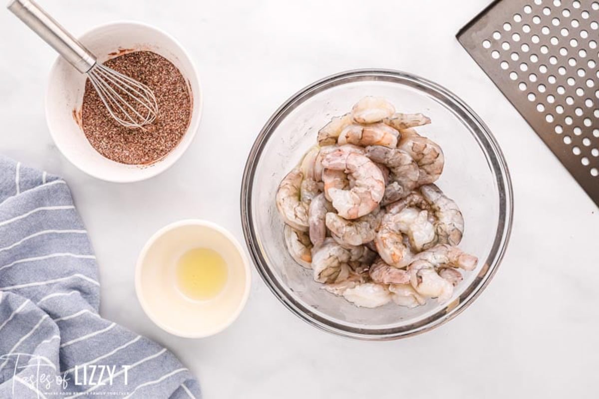 shrimp in a bowl with seasonings in a bowl on the side