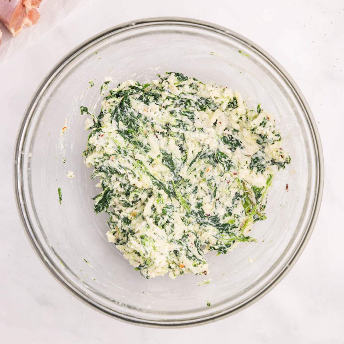 spinach and cheese mixed in a mixing bowl